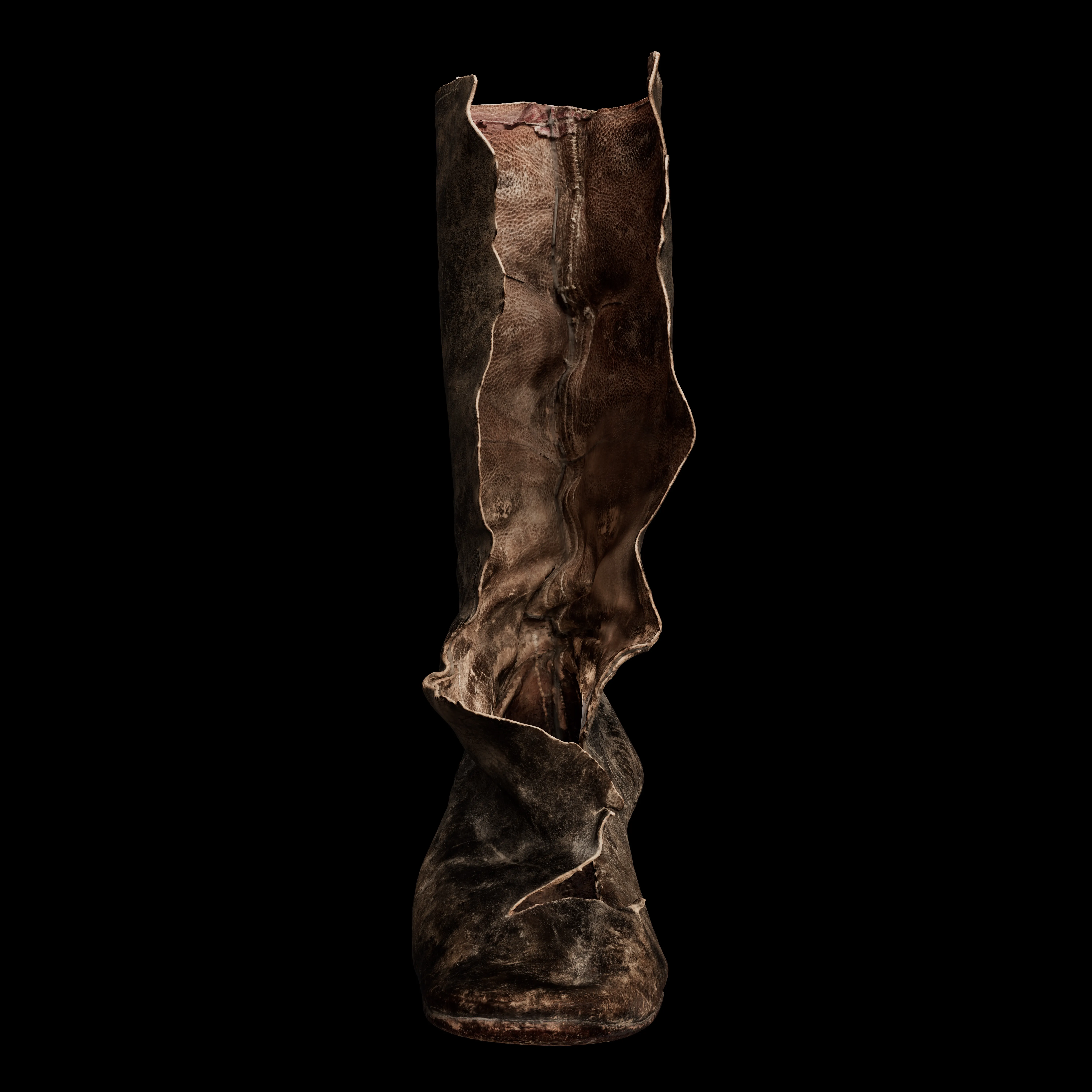 Worn, wrinkled brown leather boot that has been ripped open, standing upright against a black background.