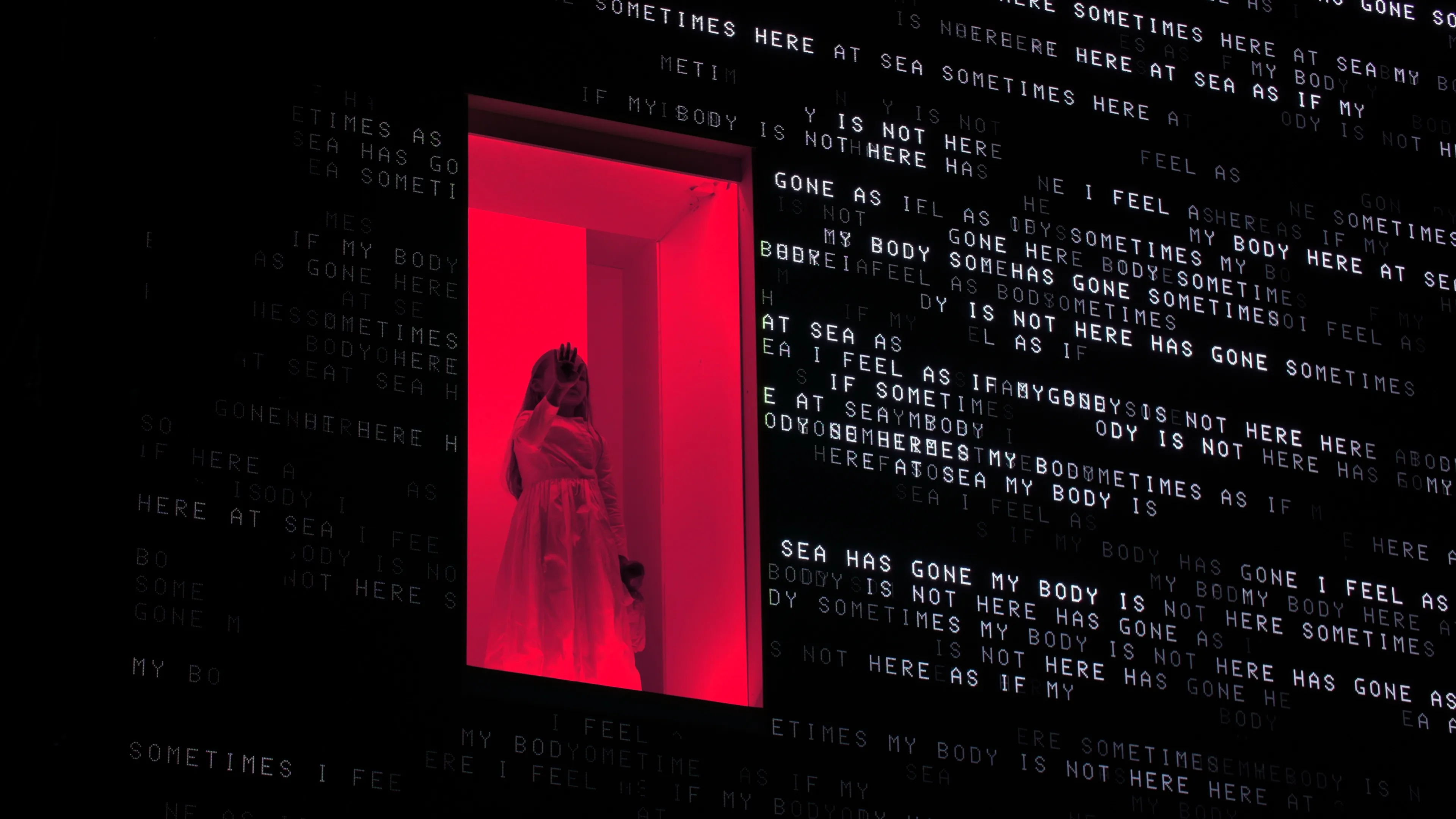 A young girl in a white dress holds her hand to the glass of an enclosure, which is set within a large LED screen displaying jumbled and overlapping poetic texts.