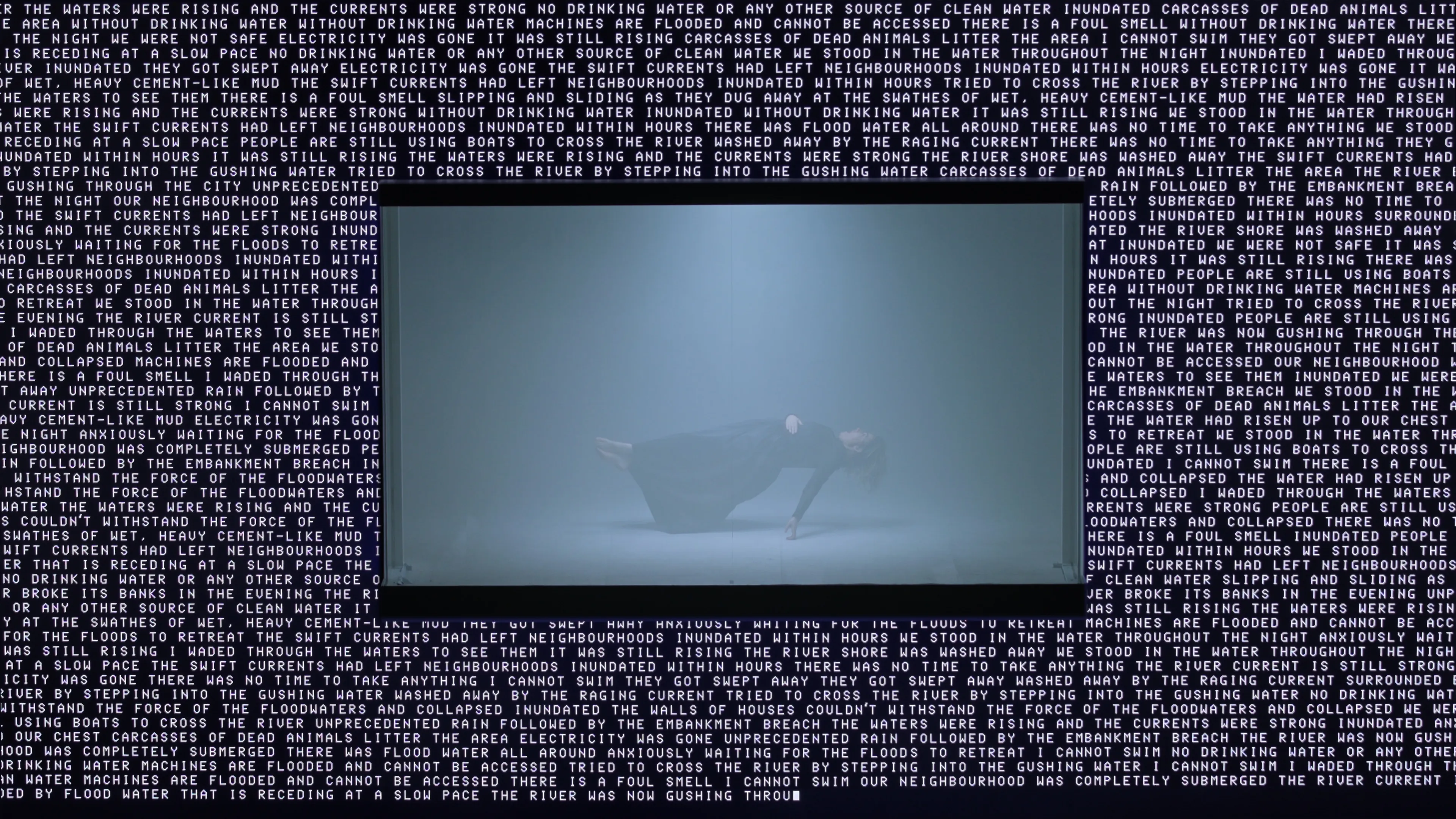 Singer floating mid-air in a glass case surruonded by text on a surrounding LED screen.