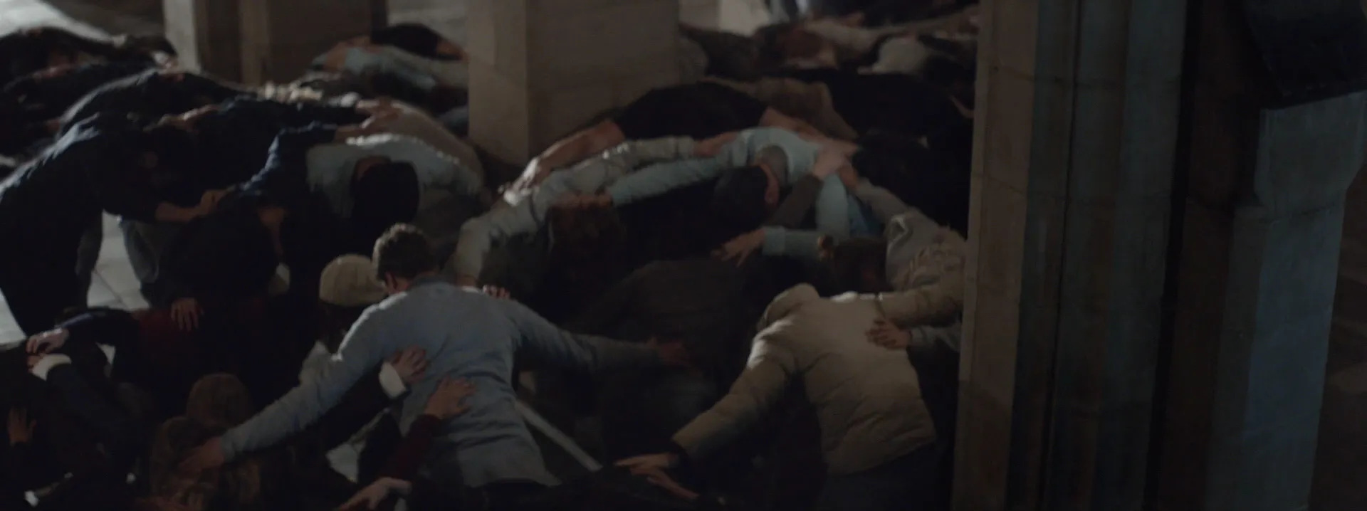 Approximately two dozen bodies hunched close together between sandstone arches.