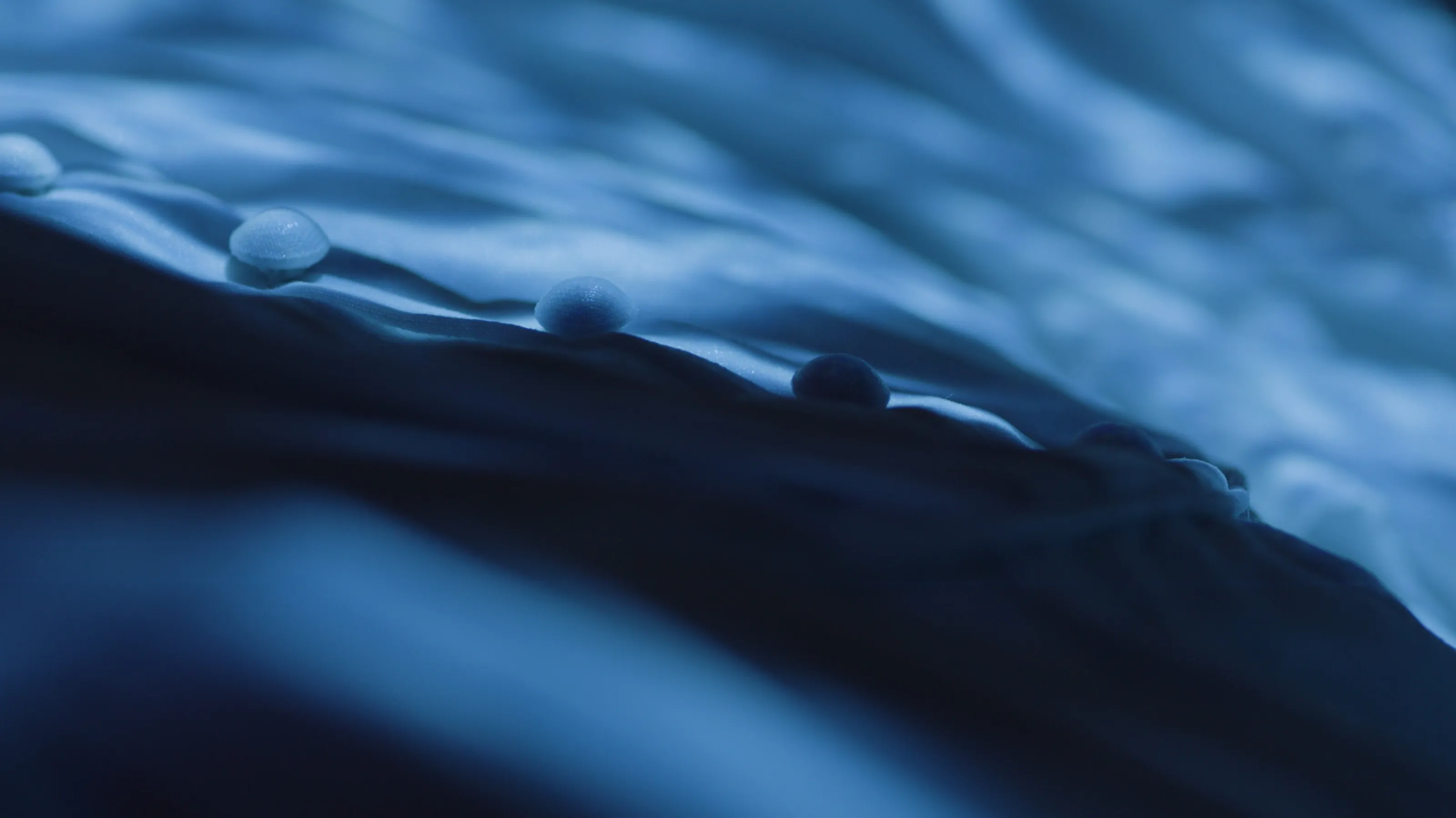 An extreme close-up of blue light projected onto a white dress.