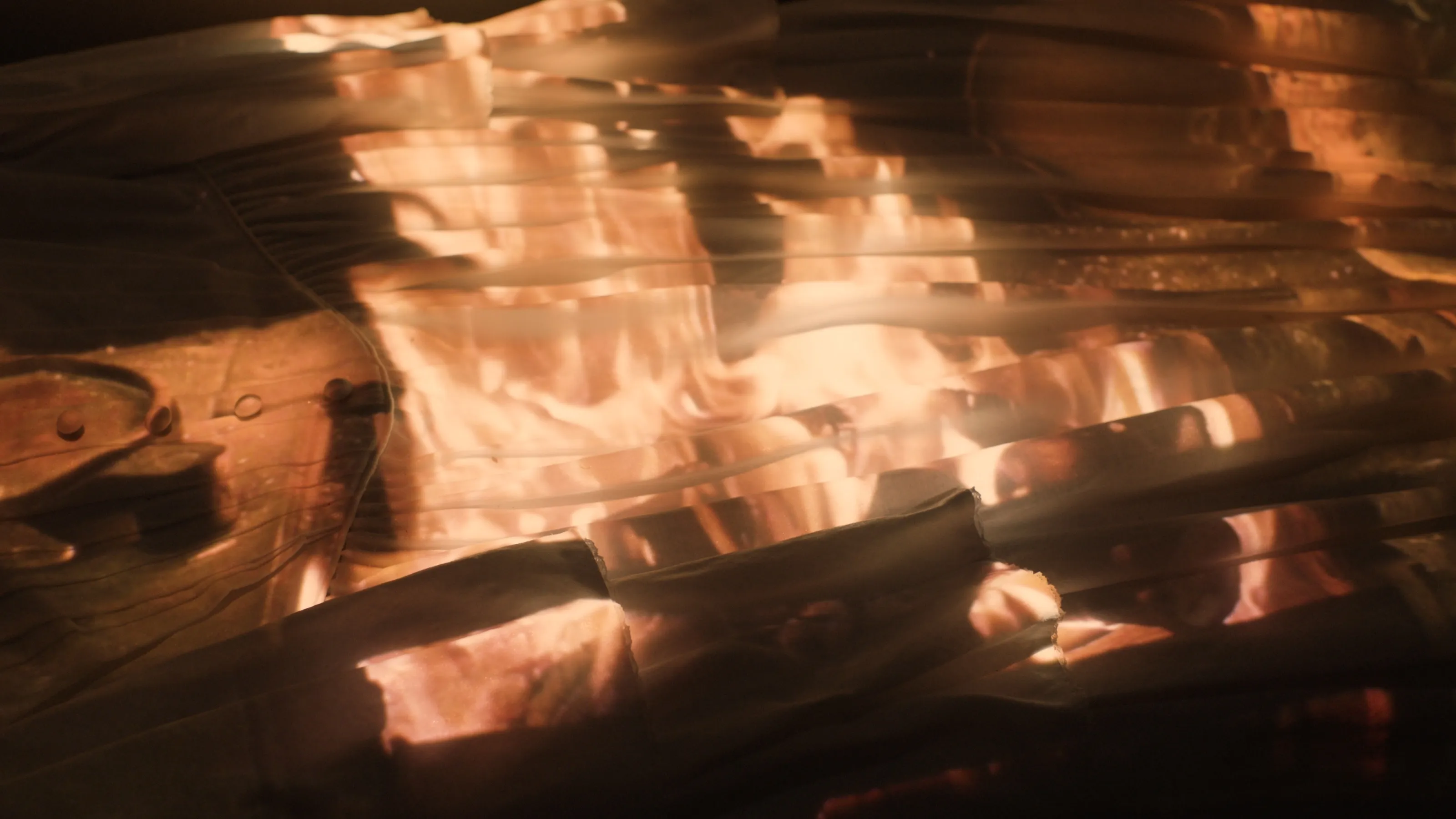 An image of fire projected onto a white dress.