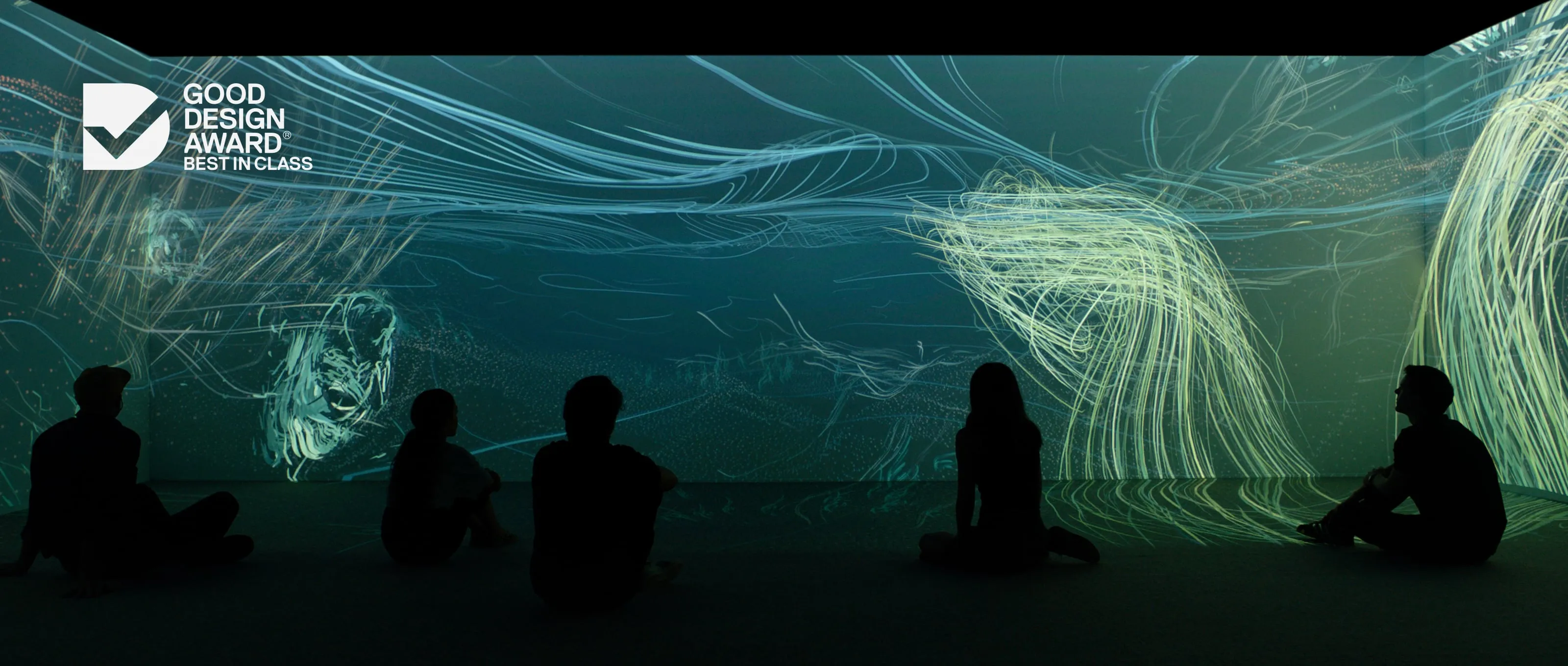 Museum visitors silhouetted against an immersive projection of flowing blue and green lines