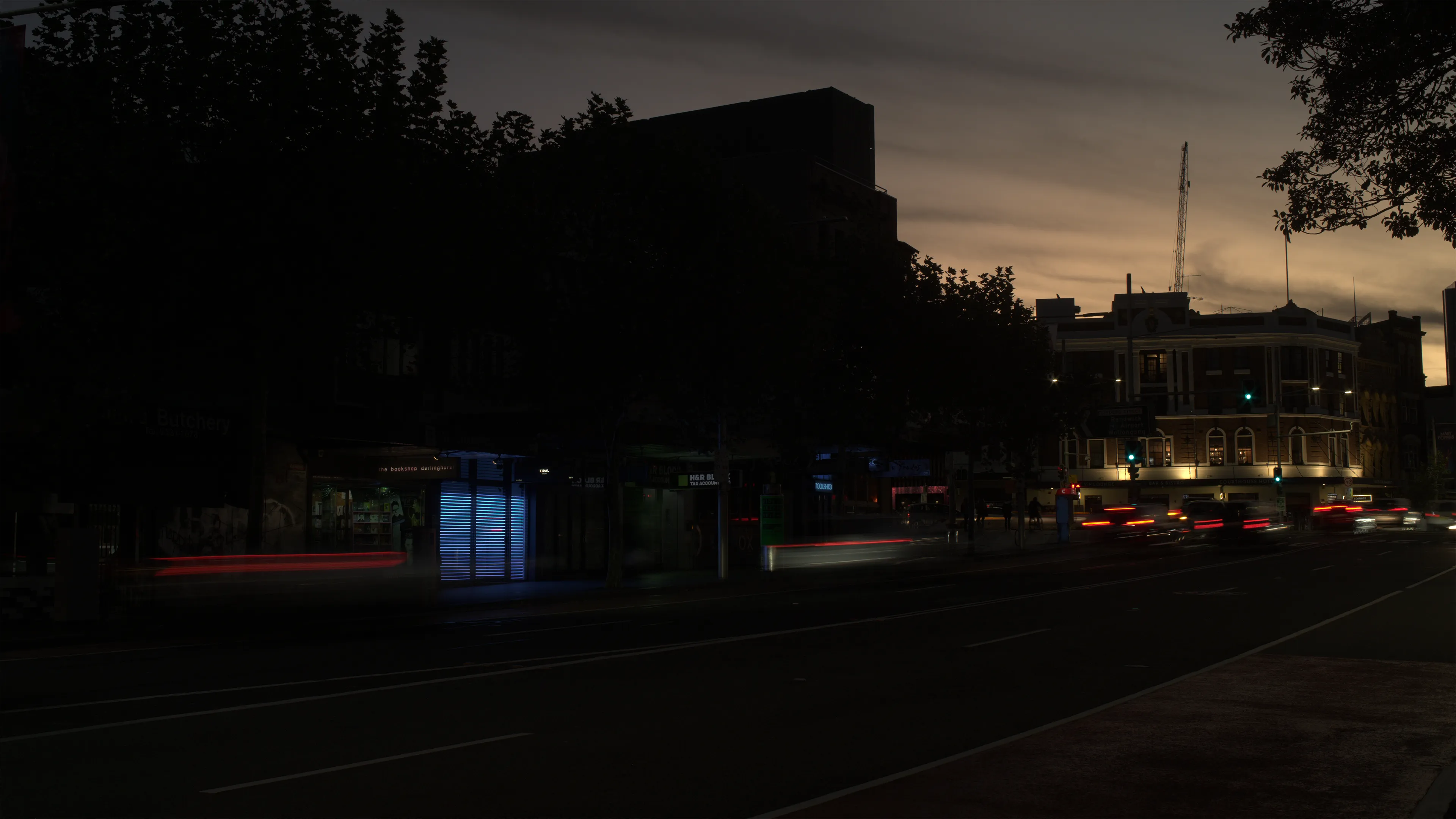 The artwork, consisting of horizontal strips of light in a shop front window, can be seen in the dark street.