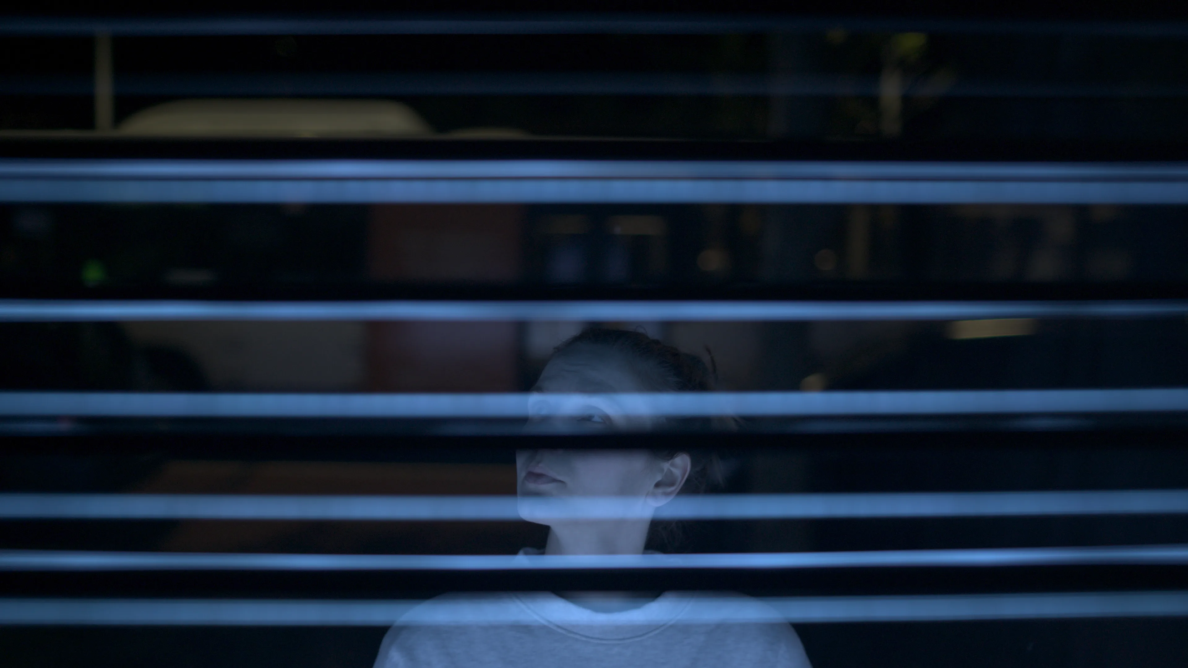 A young woman stands in front of the artwork, looking up at it.