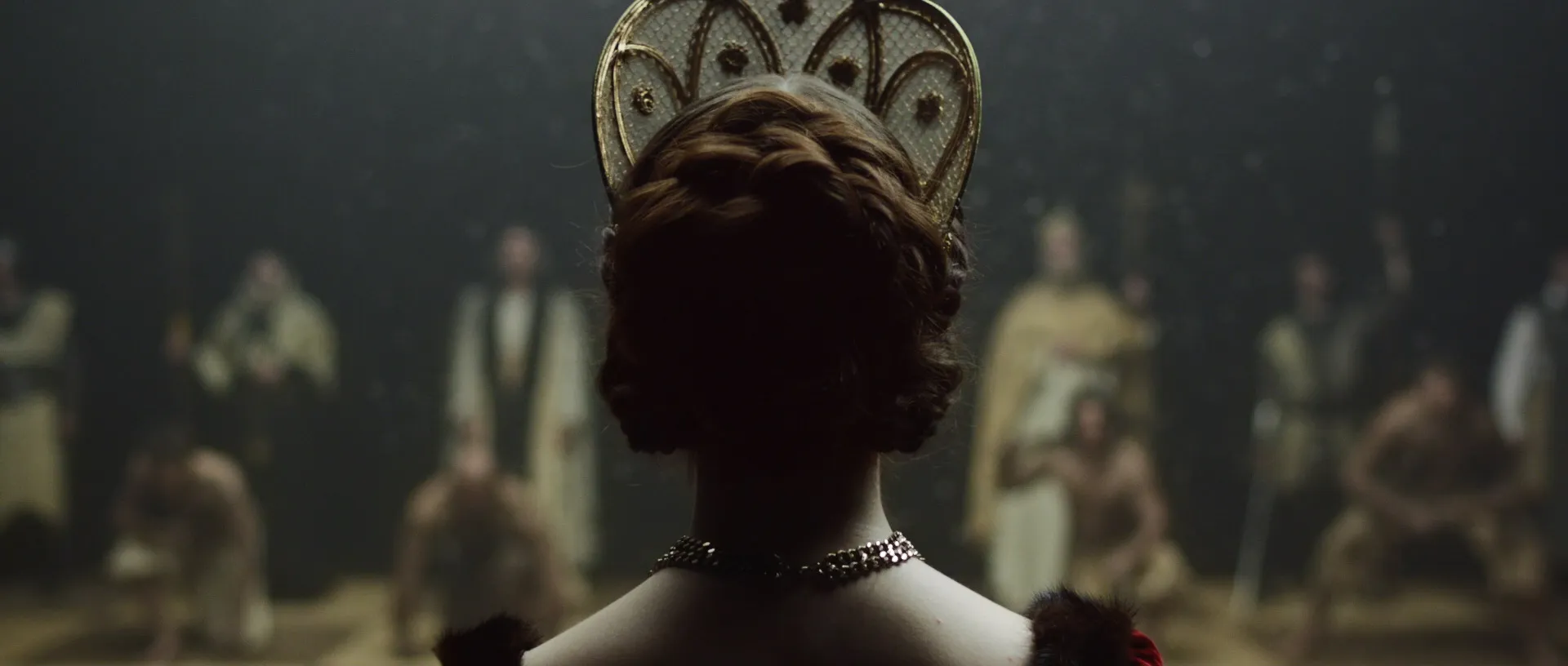The back of a queen standing in her opening chess position. The two rows of the other side can be seen in the background.